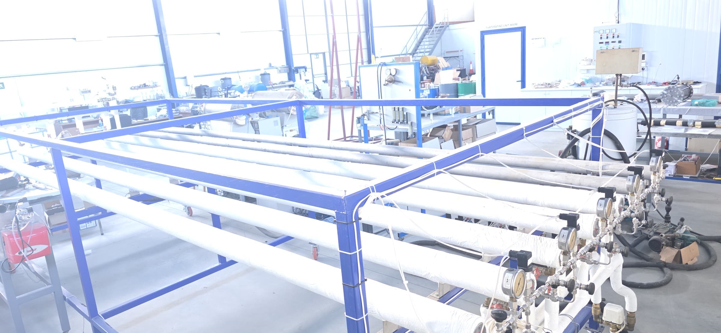 Four parallel insulated metal-hydride pipes mounted in a blue laboratory test frame with valves and gauges.