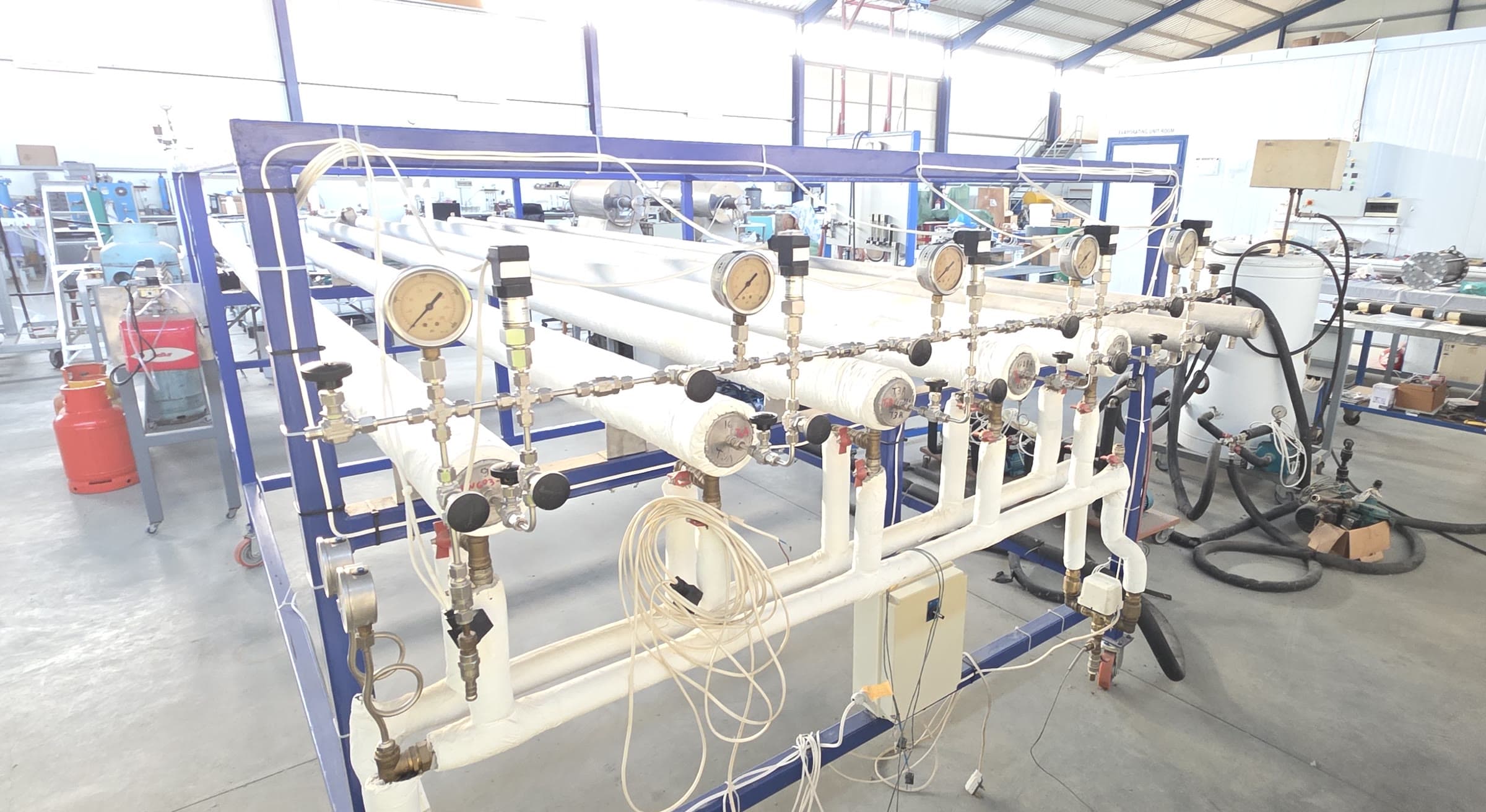 Close view of four instrumented hydride pipes with pressure gauges, valves and sensor tubing.